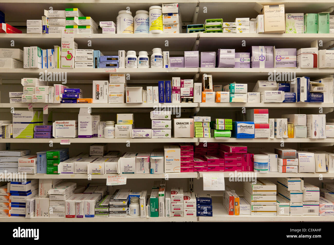 Pharmaceutical drugs on shelves in a community  dispensing chemist shop or pharmacy in England Stock Photo
