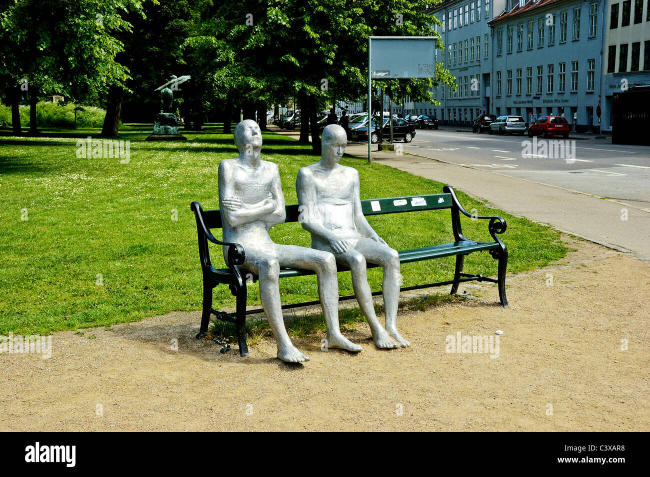 Two metal aluminum statues by the sculptor Steinunn Thórarinsdóttir sitting on a cast iron bench in Churchill Park, Copenhagen Stock Photo