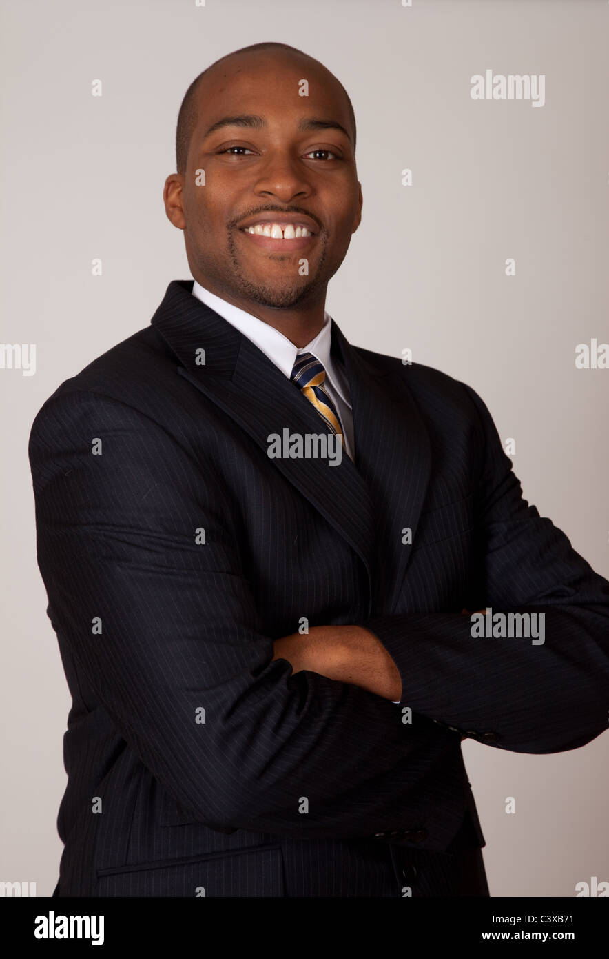 Confident, assured Black businessman with arms folded across his chest and a smile Stock Photo