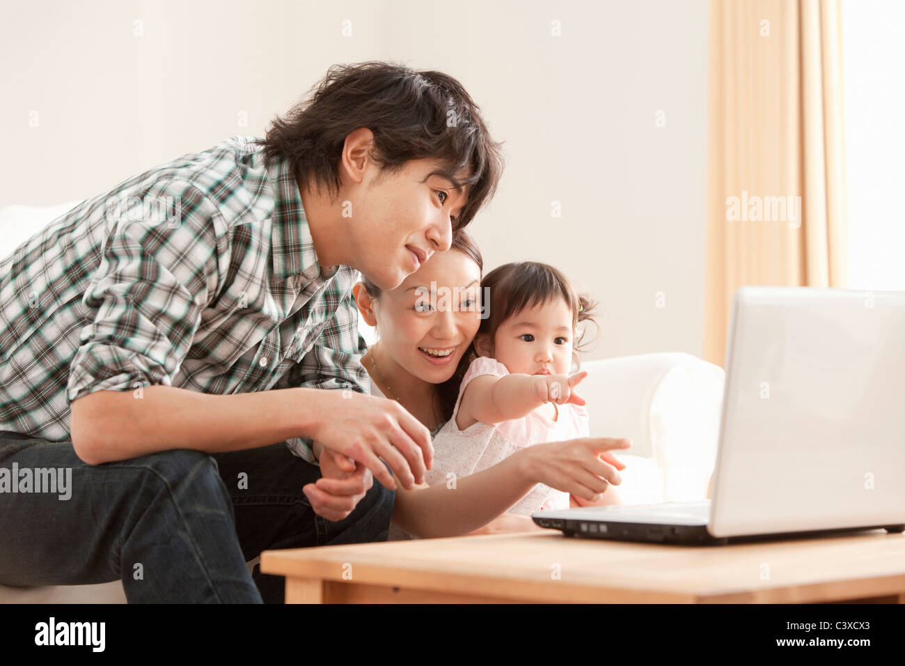 Mother, Father and Baby Girl Using Laptop Stock Photo - Alamy