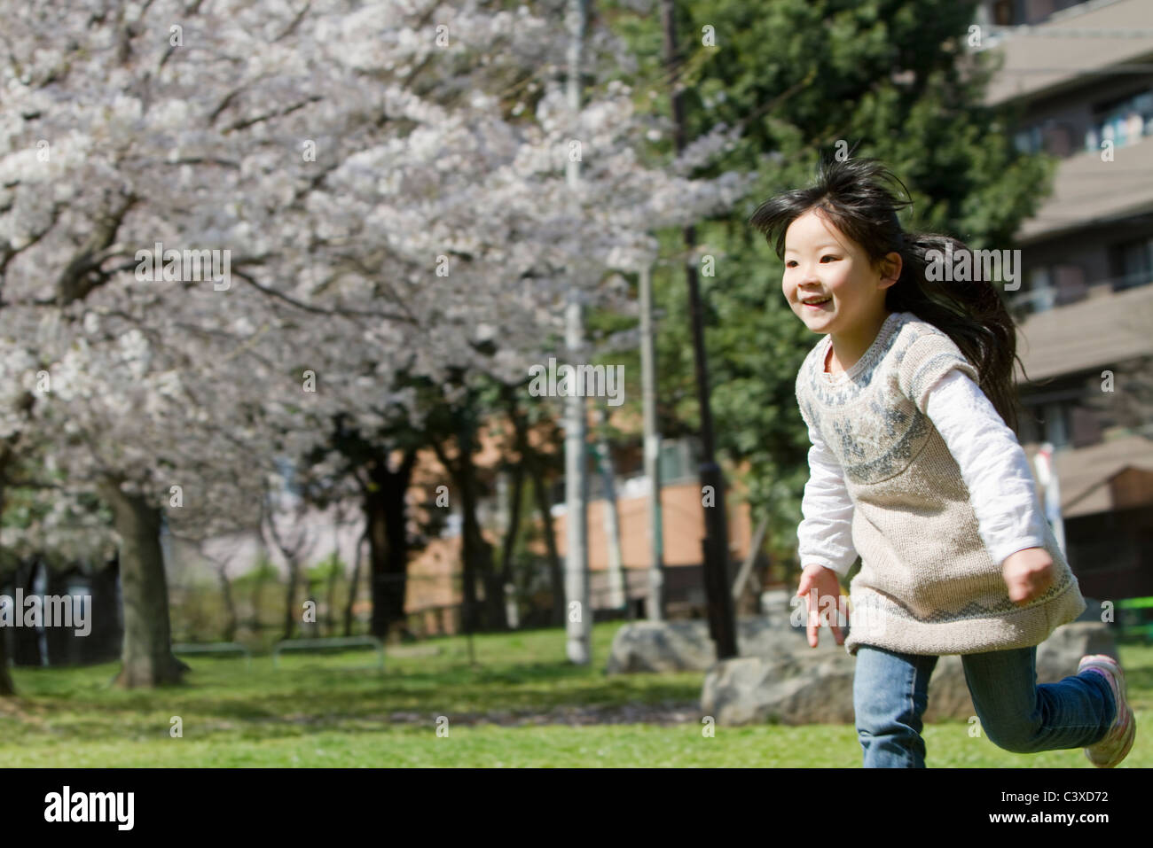Japanese Girl Running in Park Stock Photo