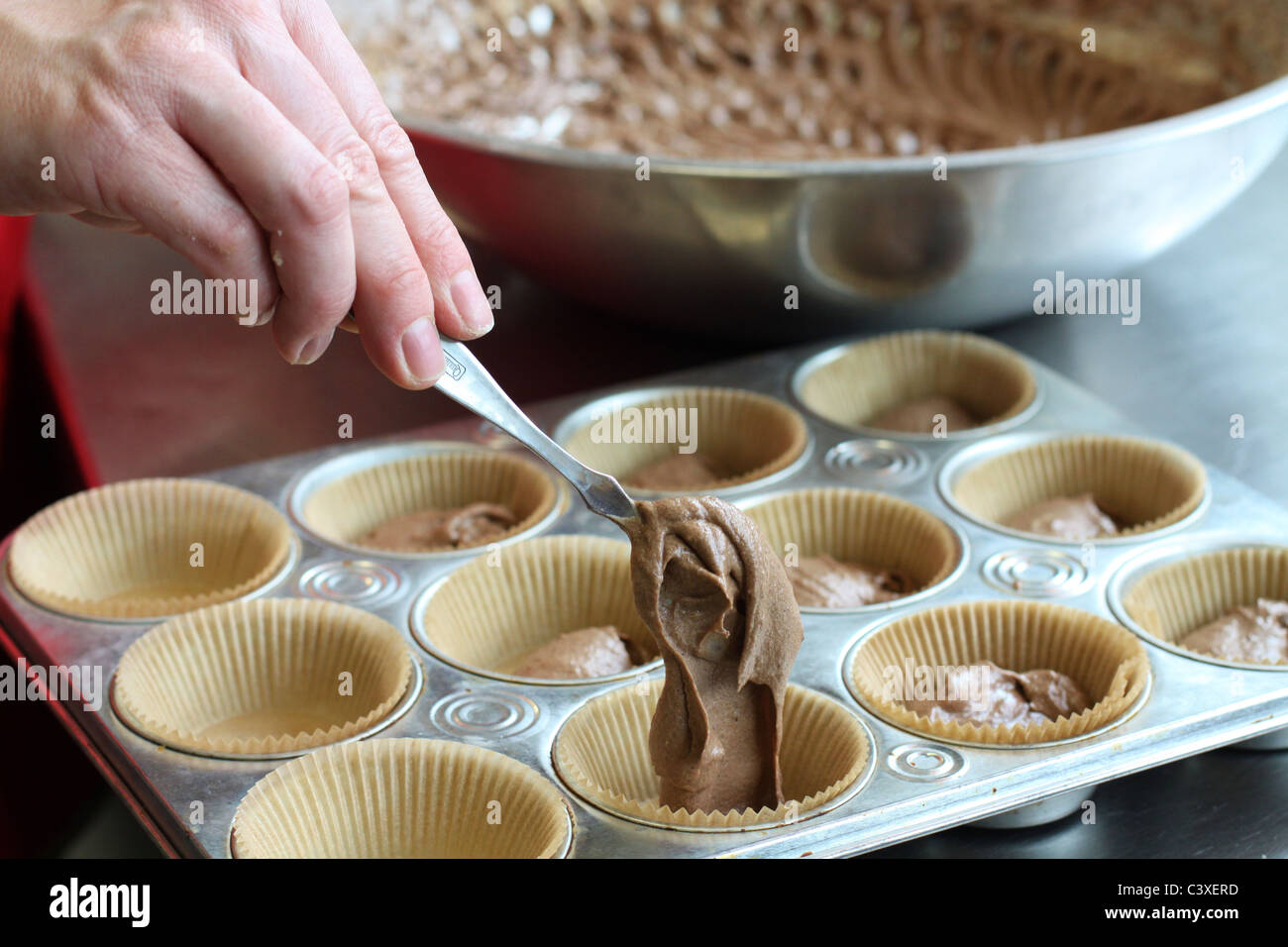 https://c8.alamy.com/comp/C3XERD/a-close-up-of-a-womans-hand-pouring-batter-into-cupcake-tins-C3XERD.jpg