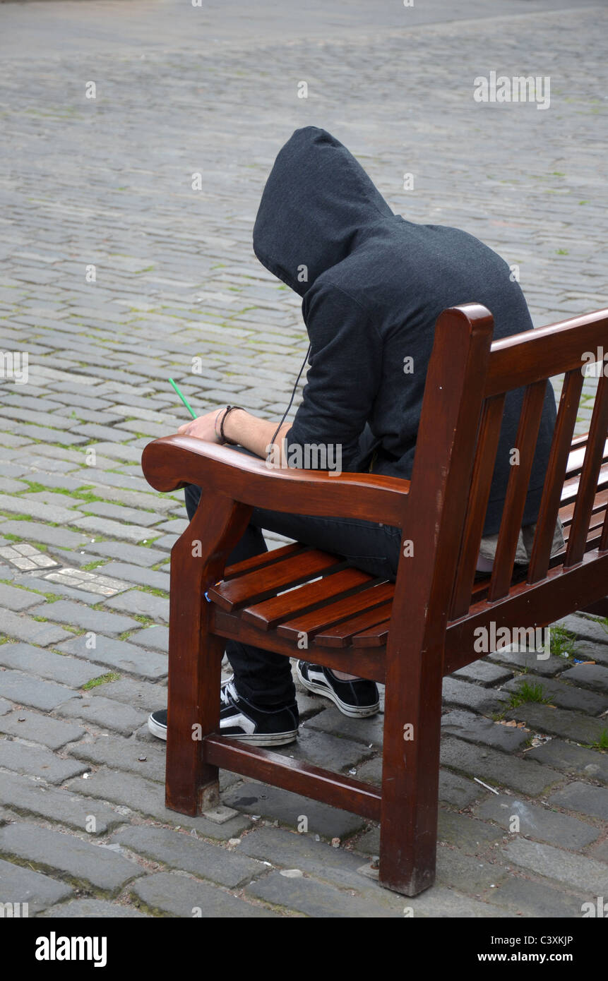 Young man wearing hoodie sitting hi-res stock photography and images - Alamy