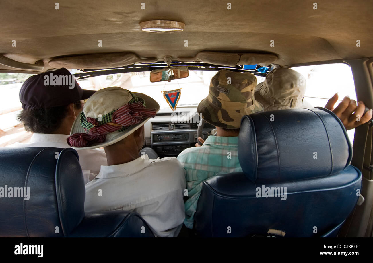Four people sit in the front of a shared taxi. Stock Photo