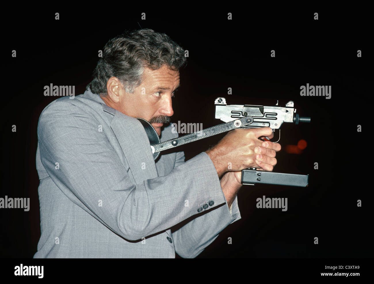 Israeli Secret Service agent draws an uzi pistol from his shoulder holster. Israel Stock Photo
