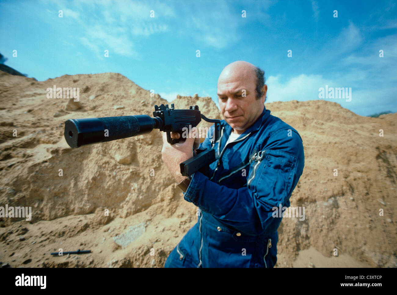 Uziel Gal, the designer and namesake of the Uzi submachine gun, holding a mini-uzi pistol with a silencer and crossed magazine. Stock Photo