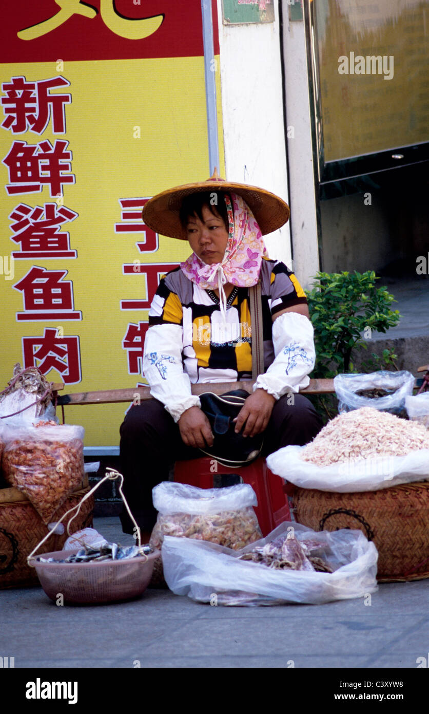 gulangyu, china. Fish monger sits on street selling dried fish and seafood.© Bob Kreisel Stock Photo