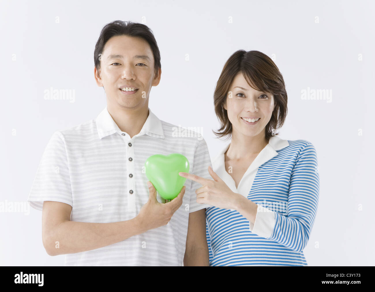 Couple holding heart-shaped balloon Stock Photo - Alamy