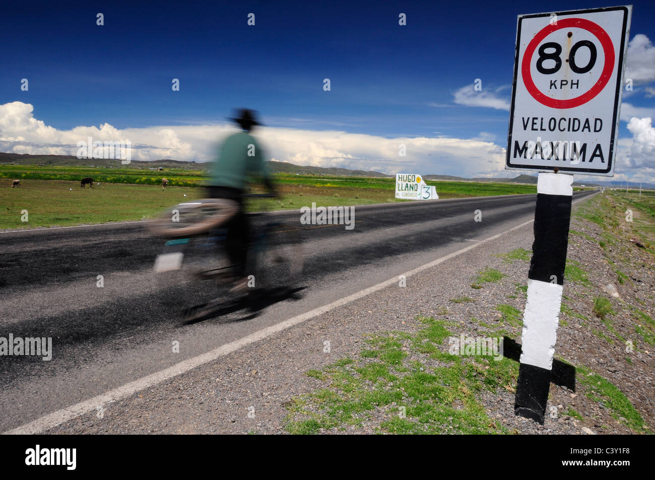 A Peruvian man driving a bicycle, on the road between Cusco and Puno, Peru Stock Photo