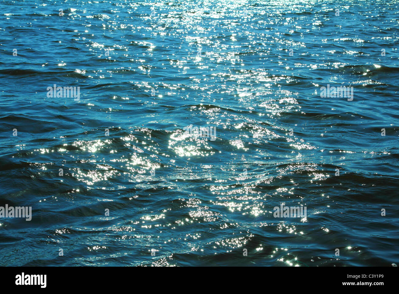 sunlight glare on surface of blue sea Stock Photo - Alamy