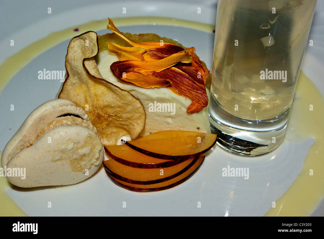 Pear based dessert plate: drink cookie Bavarian cream dried fruit nectarine slices edible flowers garnish Stock Photo