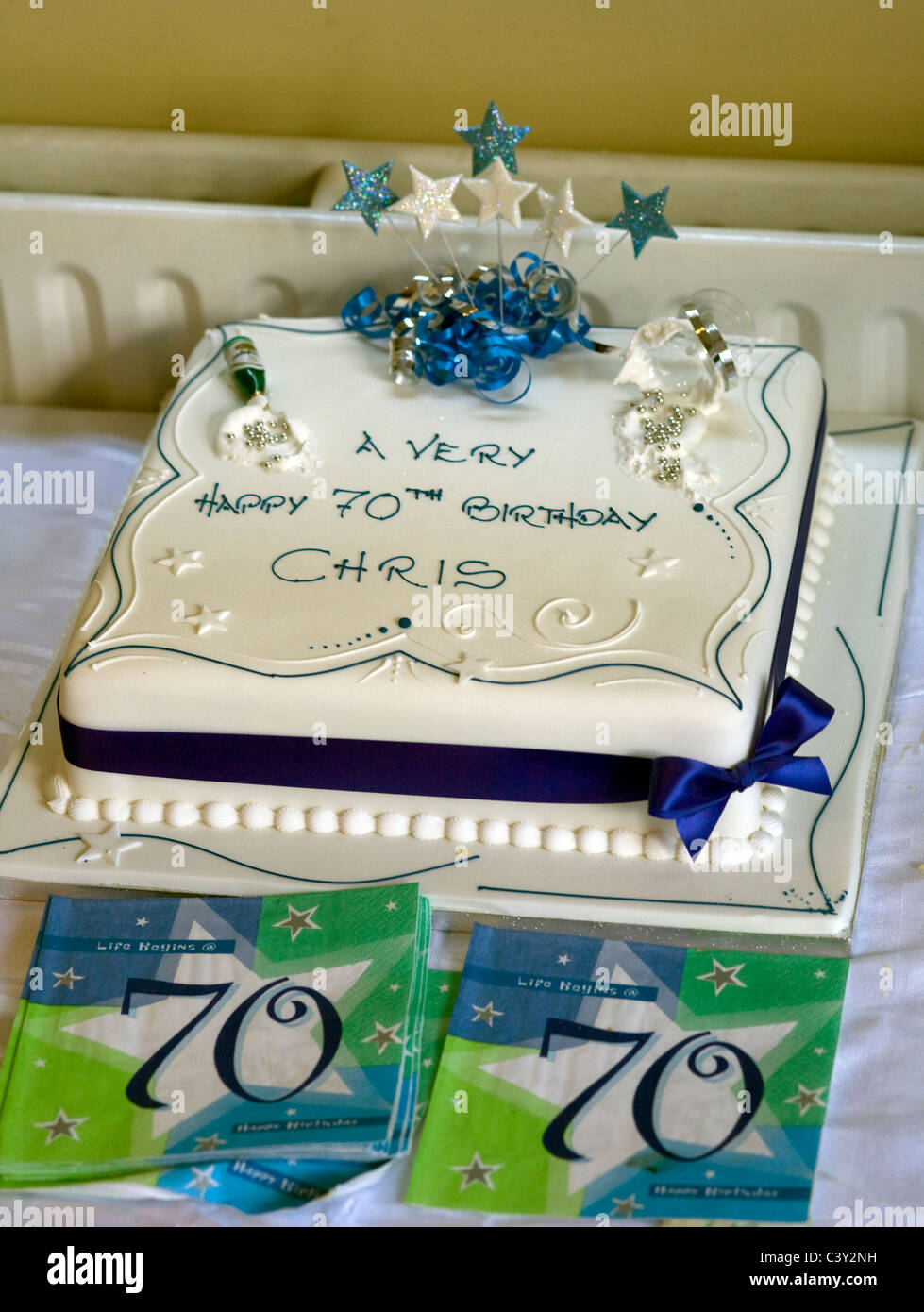 Birthday cake, with white icing and ribbon for 70th birthday of Chris Stock Photo