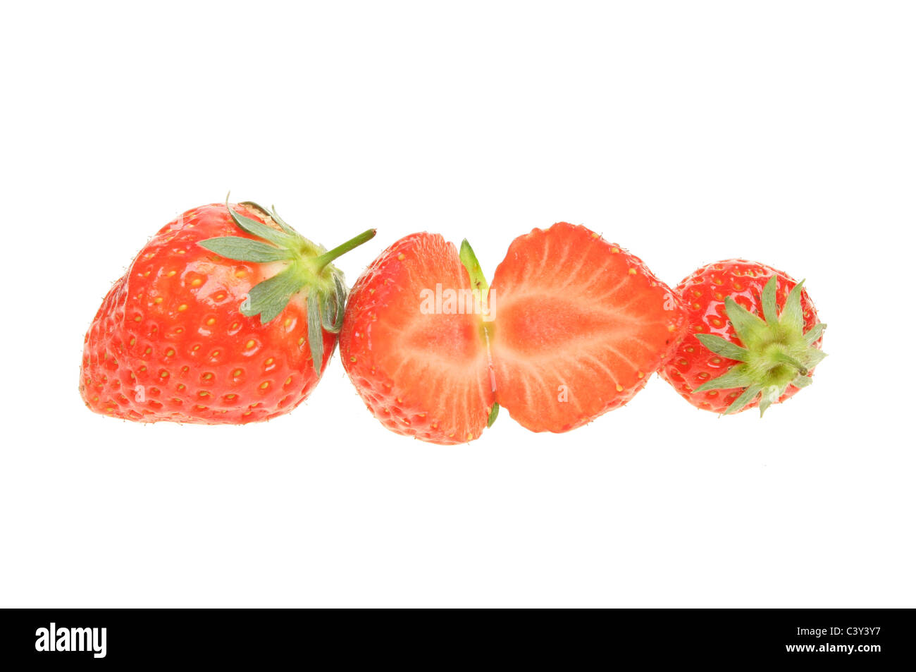 Whole and cut strawberries in a line isolated against white Stock Photo