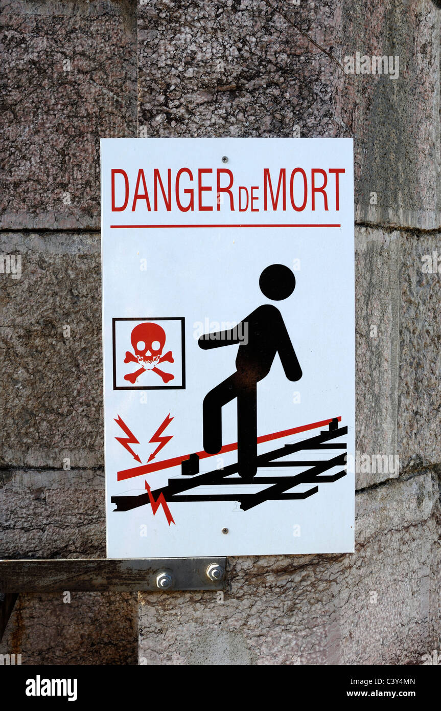 Man Treading on Electrified Railway. Electric Rail or Railway Tracks Danger Sign or Risk of Electrocution Sign France Stock Photo