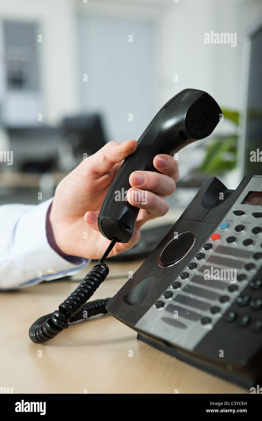 Office worker answering telephone Stock Photo - Alamy