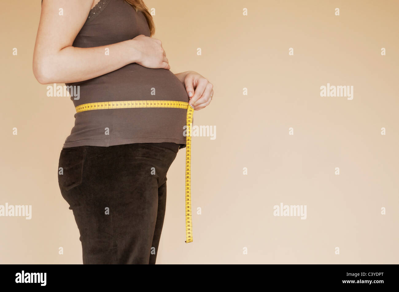 Pregnancy bump with with measuring tape, profile Stock Photo Alamy