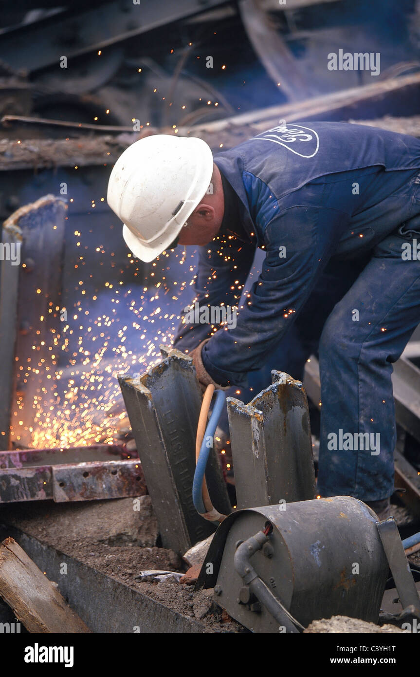 Worker using gas torch to cut up scrap metal Stock Photo - Alamy