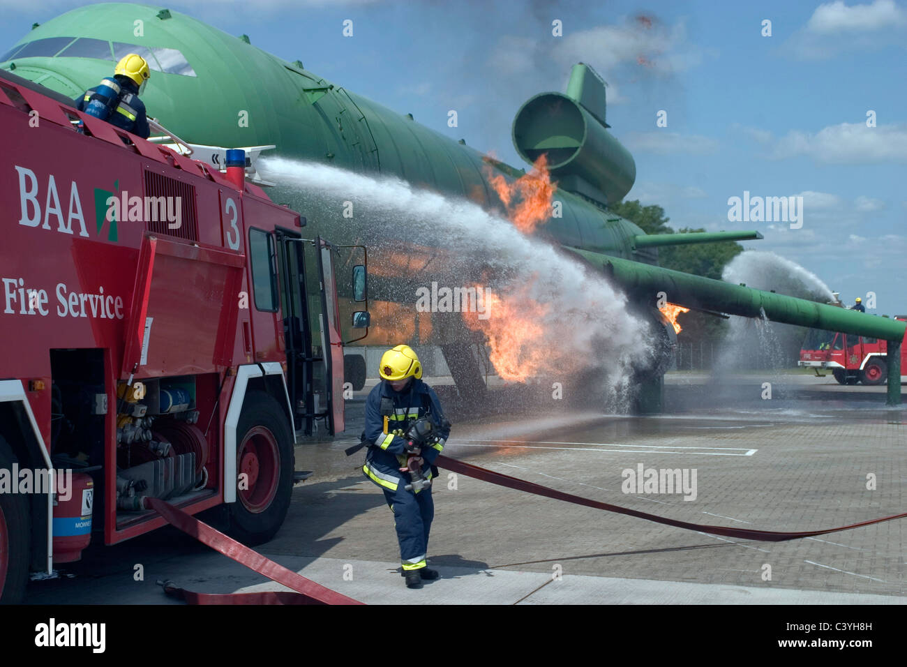 Airport fire crews practice fighting and engine fir eon an aircraft. Stock Photo