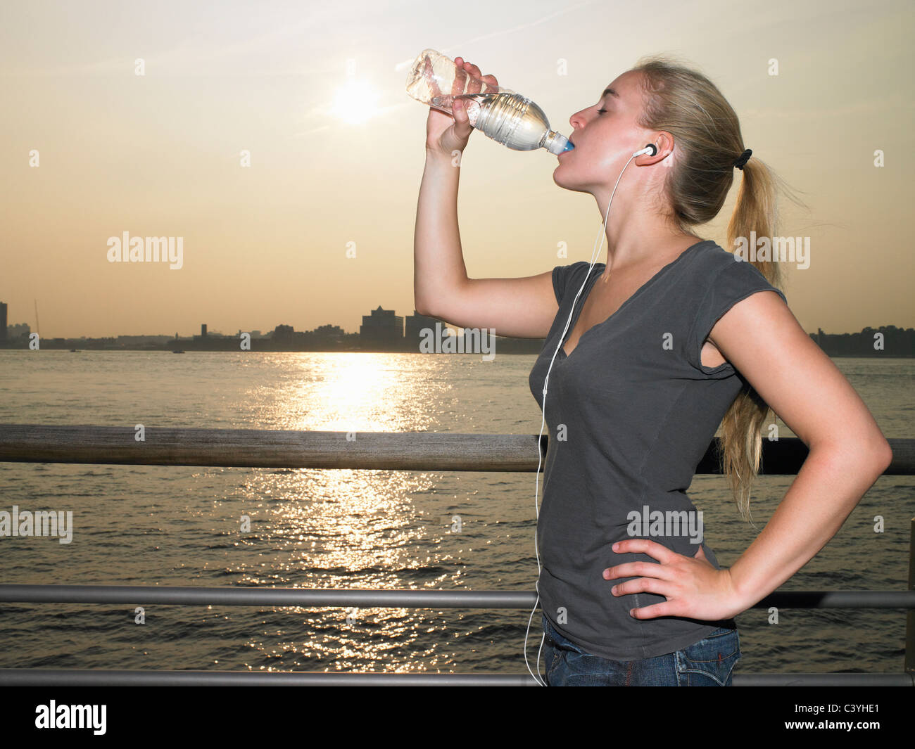 Woman with mp3 player, drinking water Stock Photo