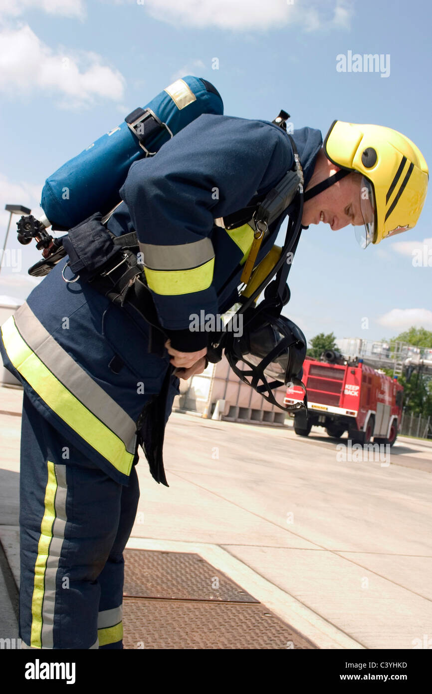 Airport firefighter adjusting his gear on a training exercise Stock Photo