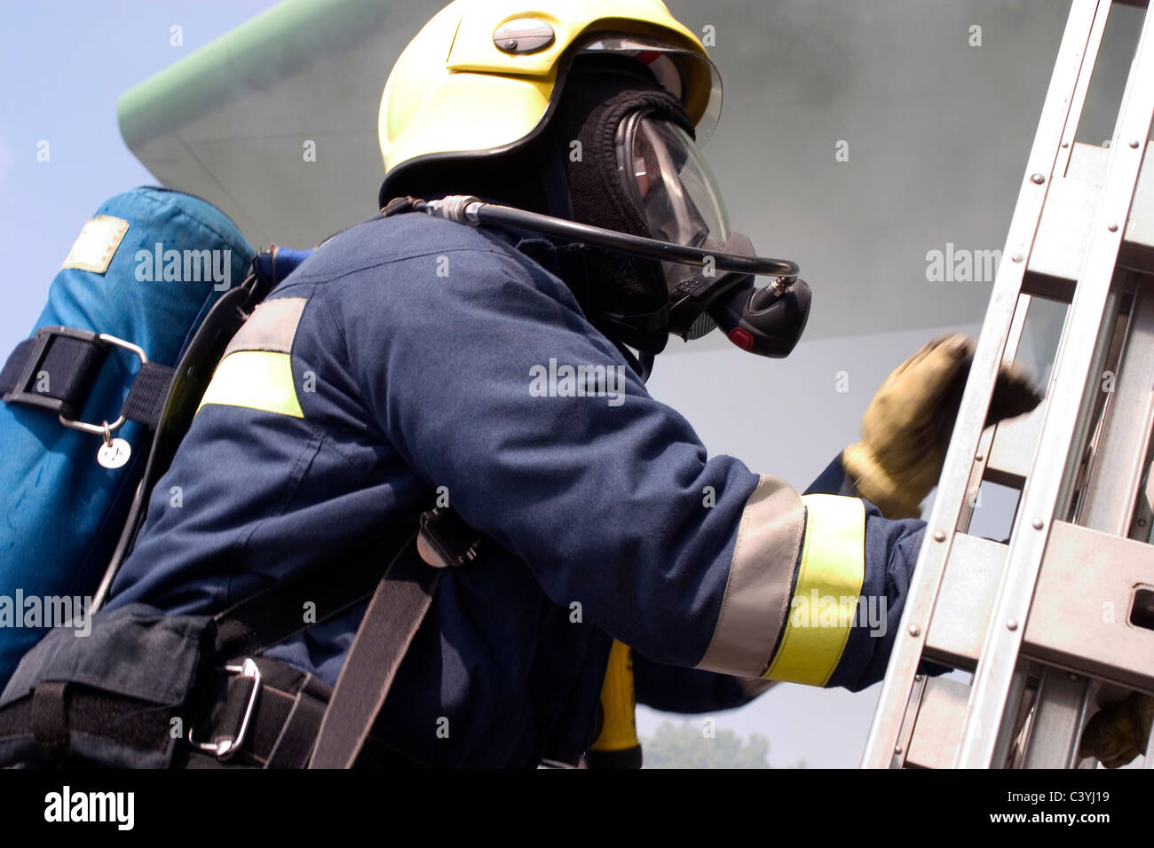Airport firefighter climbing a ladder Stock Photo