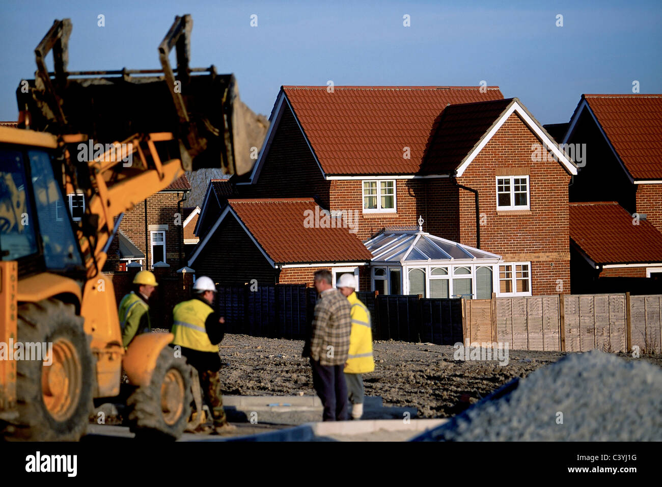 Backhoe loader and site staff at new residential development near the river Thames Thames Gateway north Kent. Stock Photo