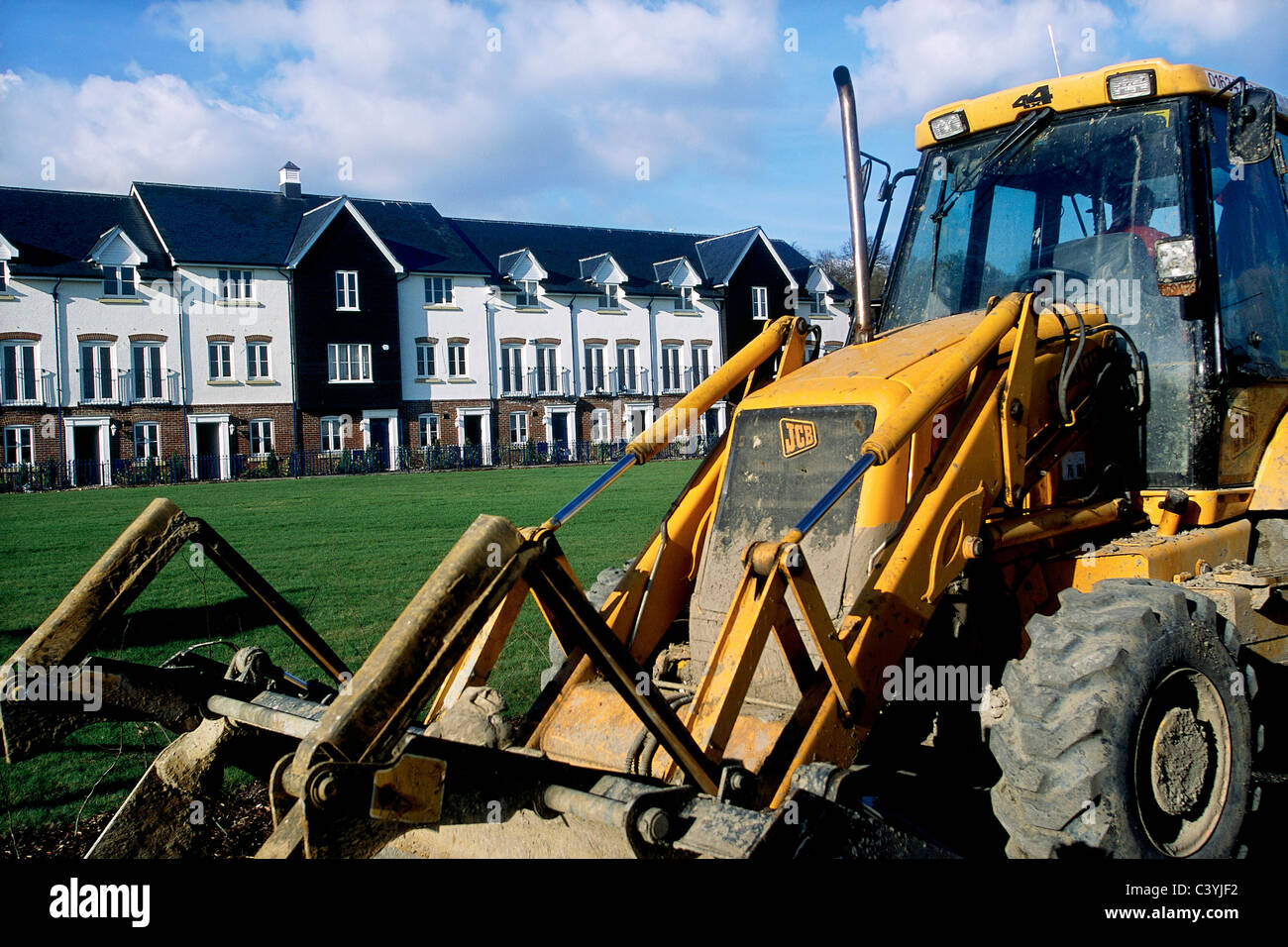 JCB backhoe loader in front of new residential development in Kent South East England. Stock Photo