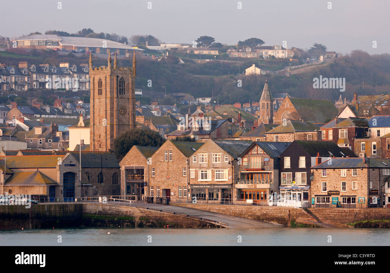 St Ives Parish Church, shops and tightly packed houses overlook the picturesque harbour at St Ives, Cornwall, England. Stock Photo
