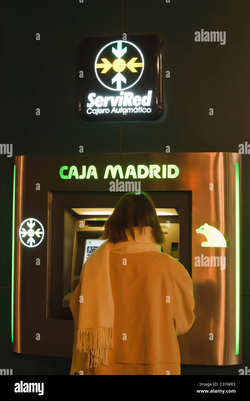 Woman in front of cash machine of Caja Madrid savings bank, Torremolinos,Costa del Sol, Spain Stock Photo