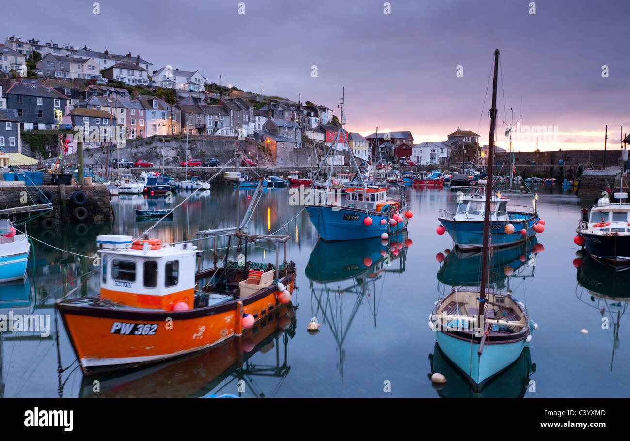 Fishing boats crowd a placid Mevagissey Harbour at dawn, Mevagissey, South Cornwall, England. Spring (May) 2011. Stock Photo