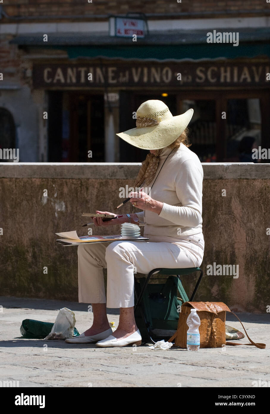 A woman painting with watercolours in a campo in Venice, Italy Stock Photo