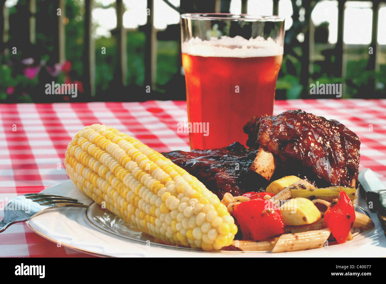 Perfect Holiday BBQ, complete with baby back ribs, corn on the cob, vegetables, and a wonderful wheat pale ale. Stock Photo