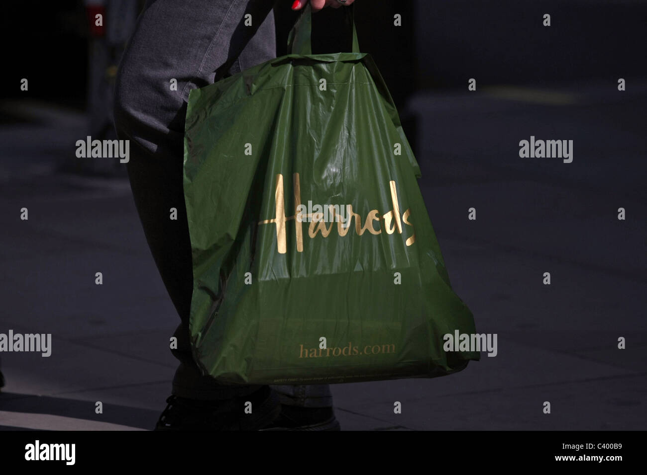 A plastic Harrods shopping bag being carried by a shopper Stock Photo ...