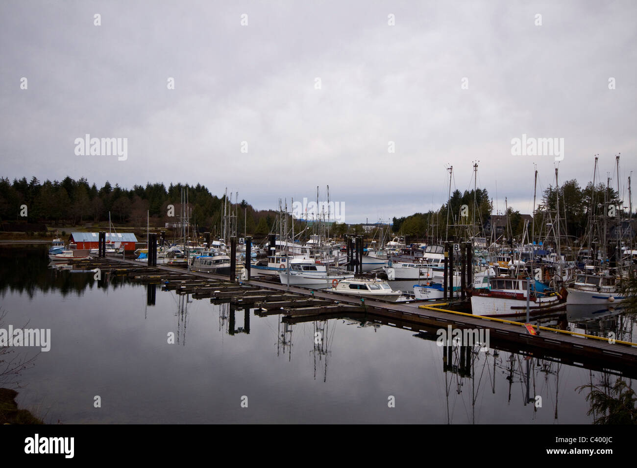 Various boats lined up and reflected in Ucluelet Harbour, Vancouver Island, British Columbia Stock Photo