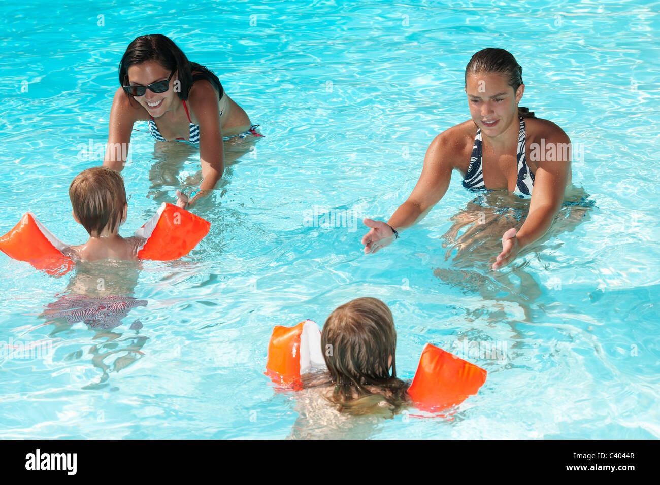 Women teaching to kids how to swim Stock Photo