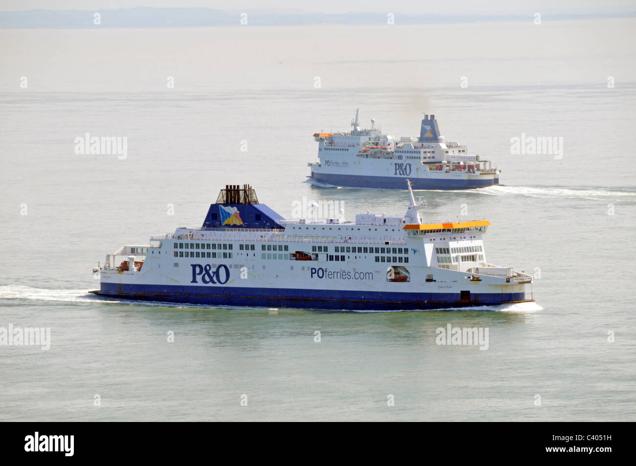 P&O passenger ferries departing and arriving in the Straits of Dover with French coastline distant in haze seen from Kent England UK Stock Photo