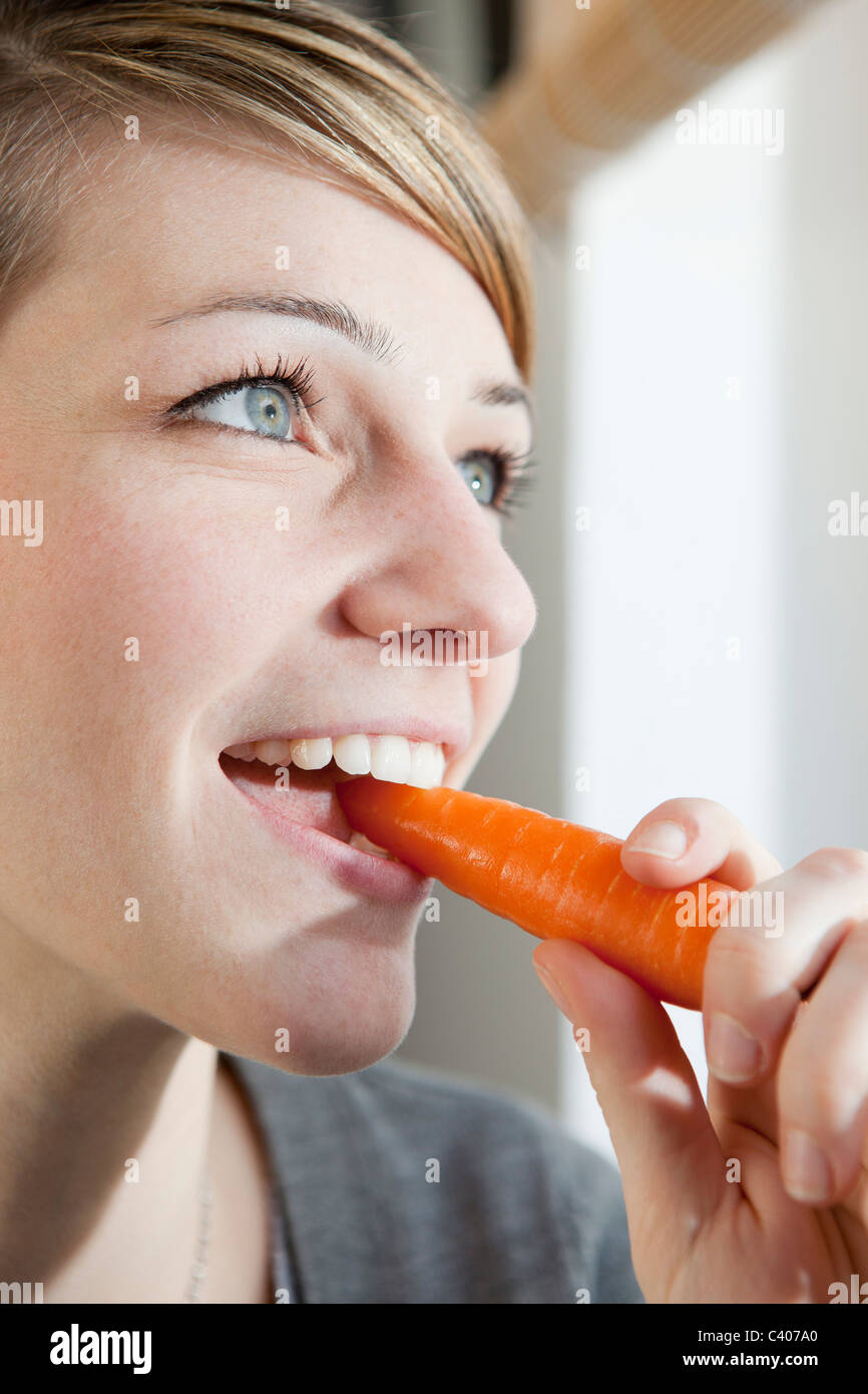 Woman eating a carrot Stock Photo