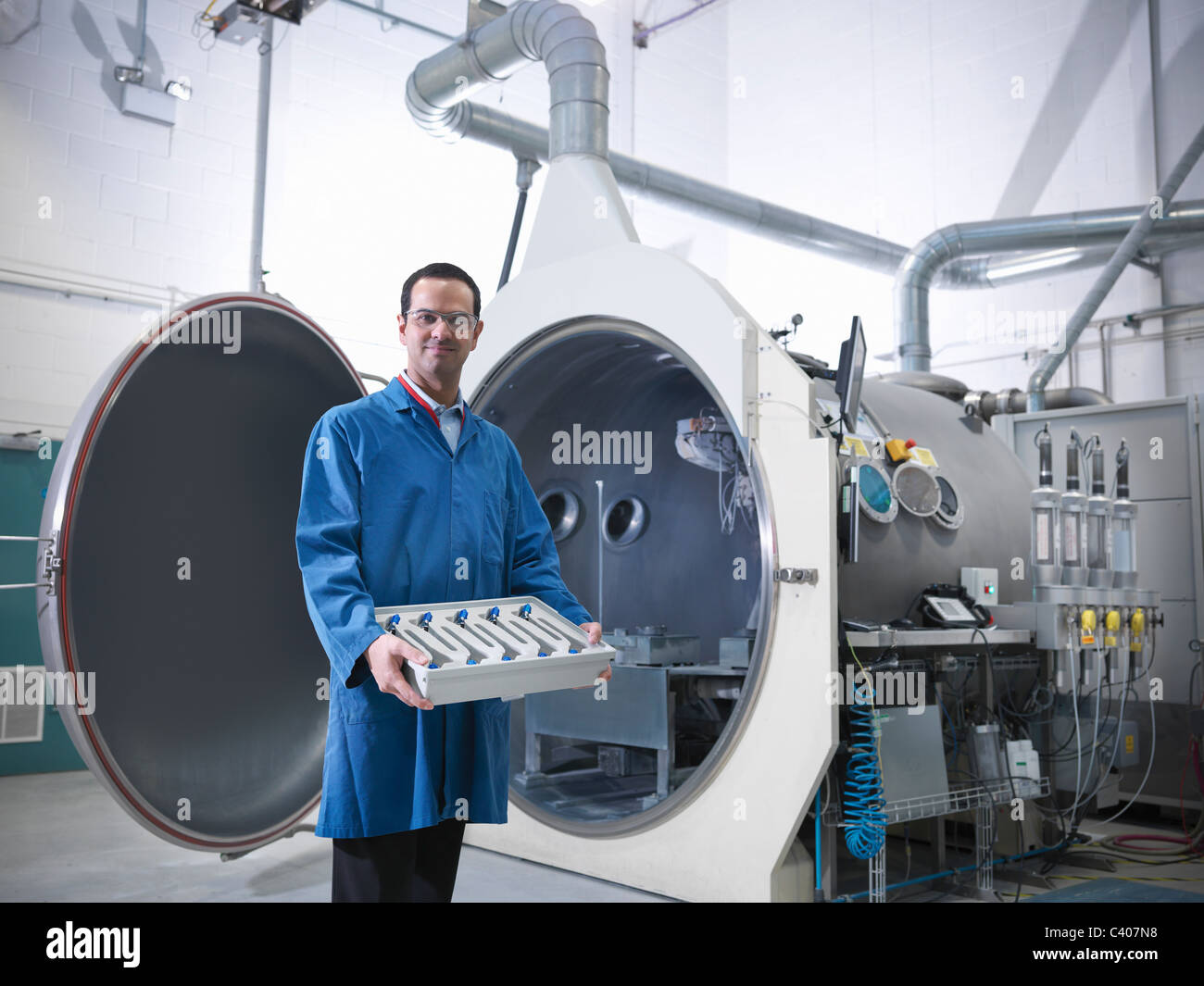 Scientist with product and vacuum tank Stock Photo