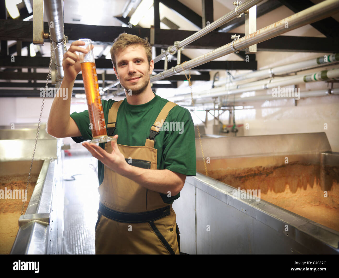 Worker with sample in fermentation room Stock Photo