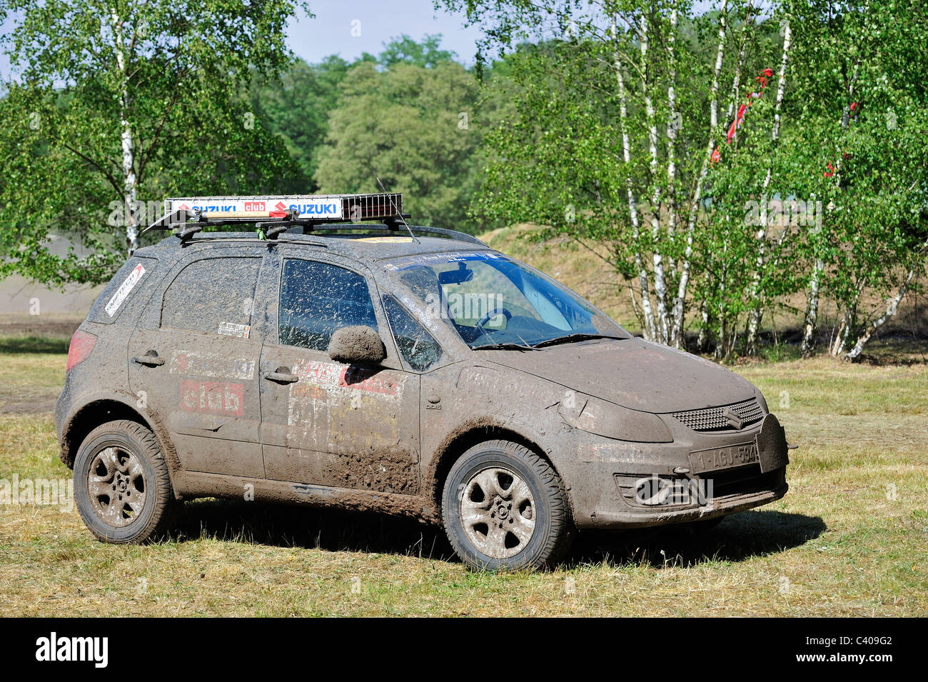 Suzuki SX4 four-wheel drive off-road vehicle covered in mud after rally cross-country racing Stock Photo