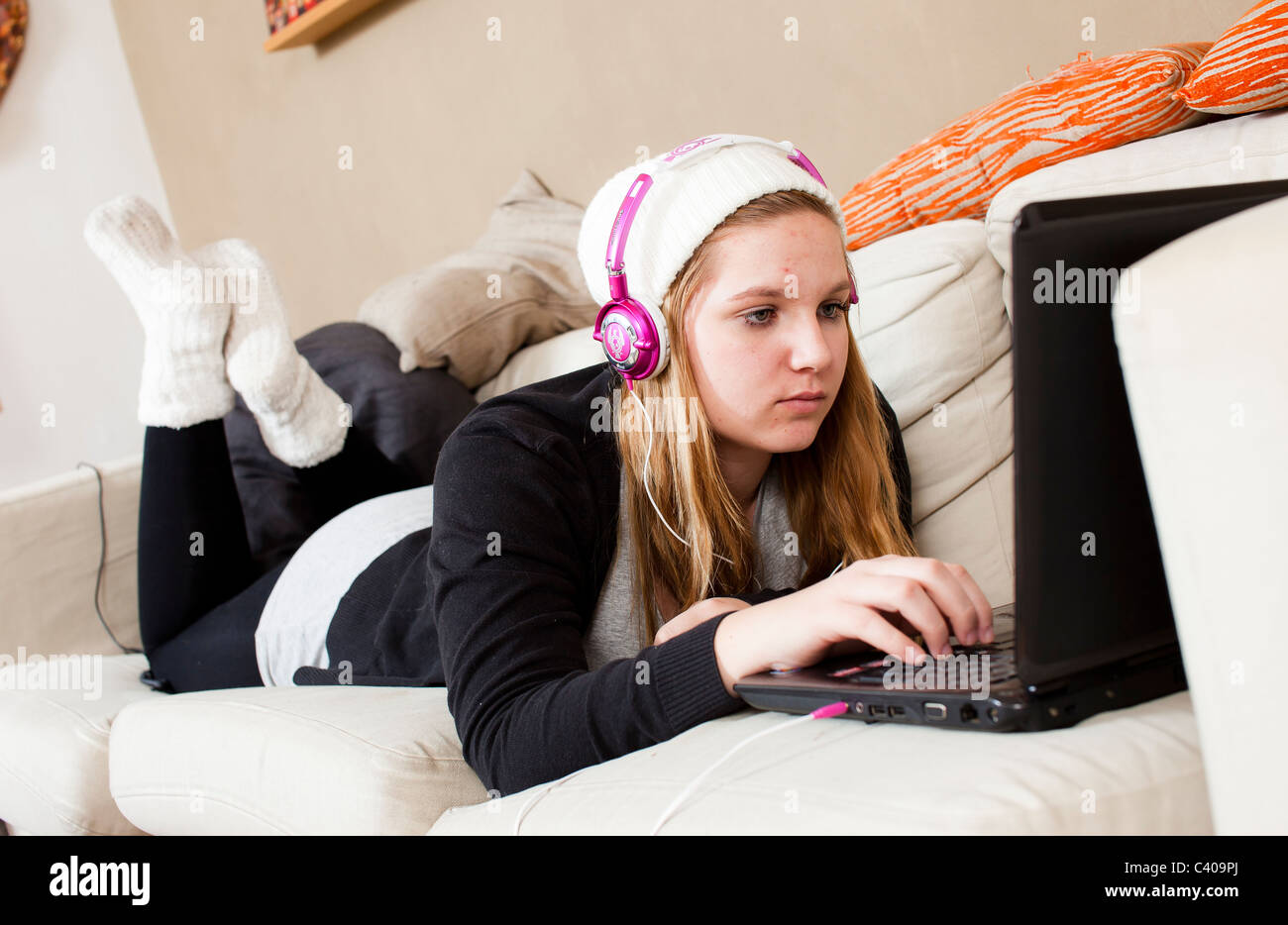 Teenagers are hard to reach when online, with earphones and totally in their own world. Stock Photo