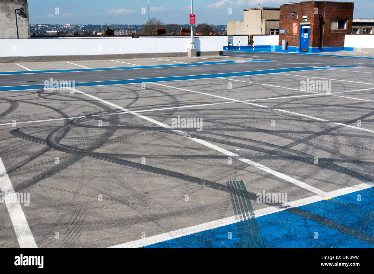 Rubber tyre-marks on the surface of an empty rooftop car park. Stock Photo