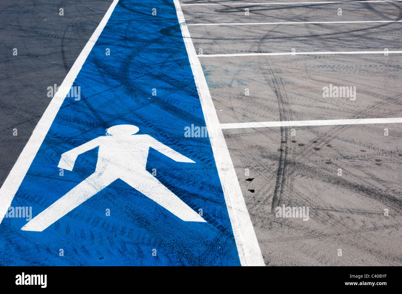 A safe pedestrian walkway is marked on the surface of an empty rooftop car park. Stock Photo