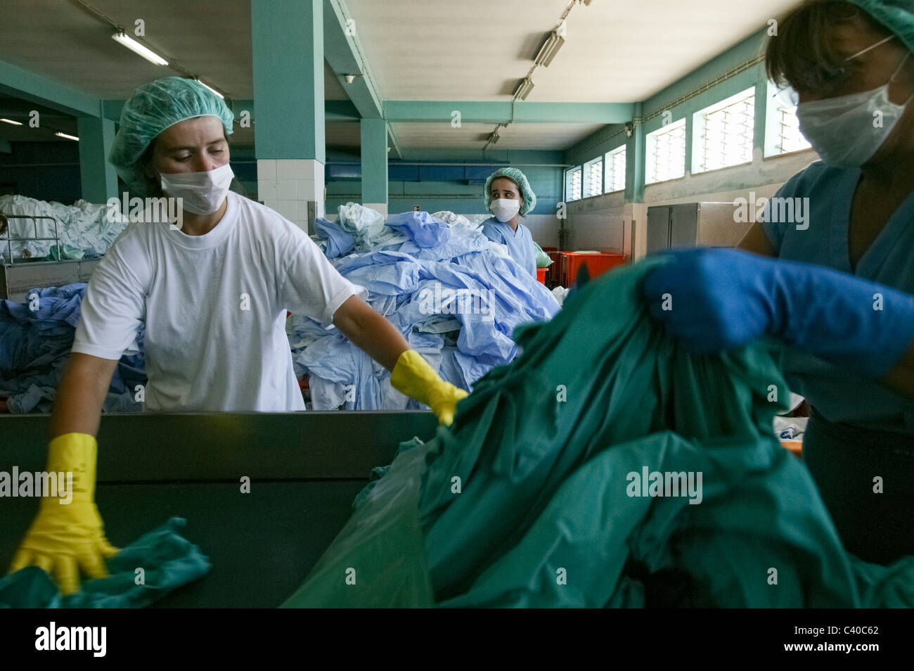 Female workers sorting clothes at an hospital laundry facilities Stock