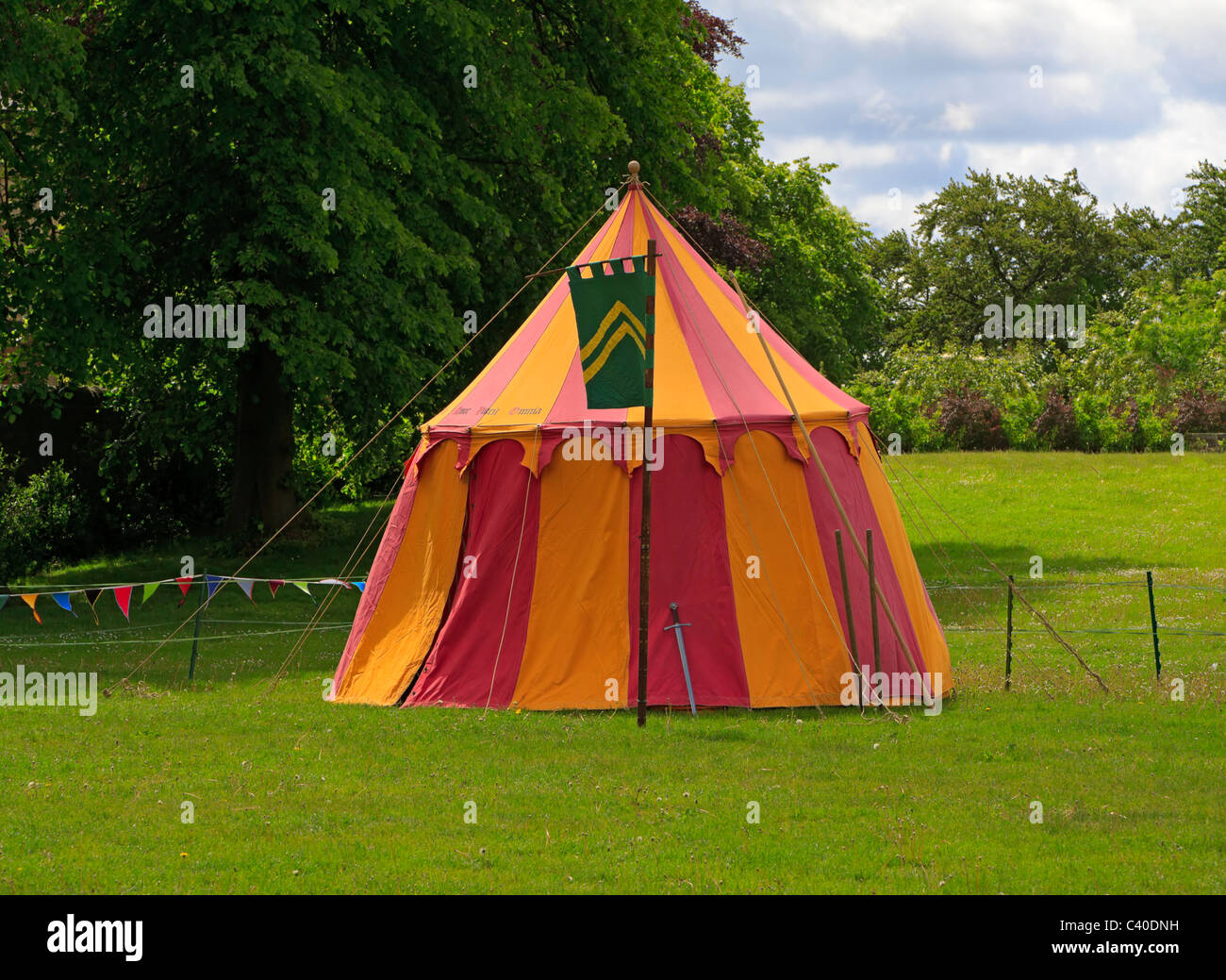 Pavillion tent in the grounds of a castle during a reenactment event. A sword leans against the tent. Stock Photo