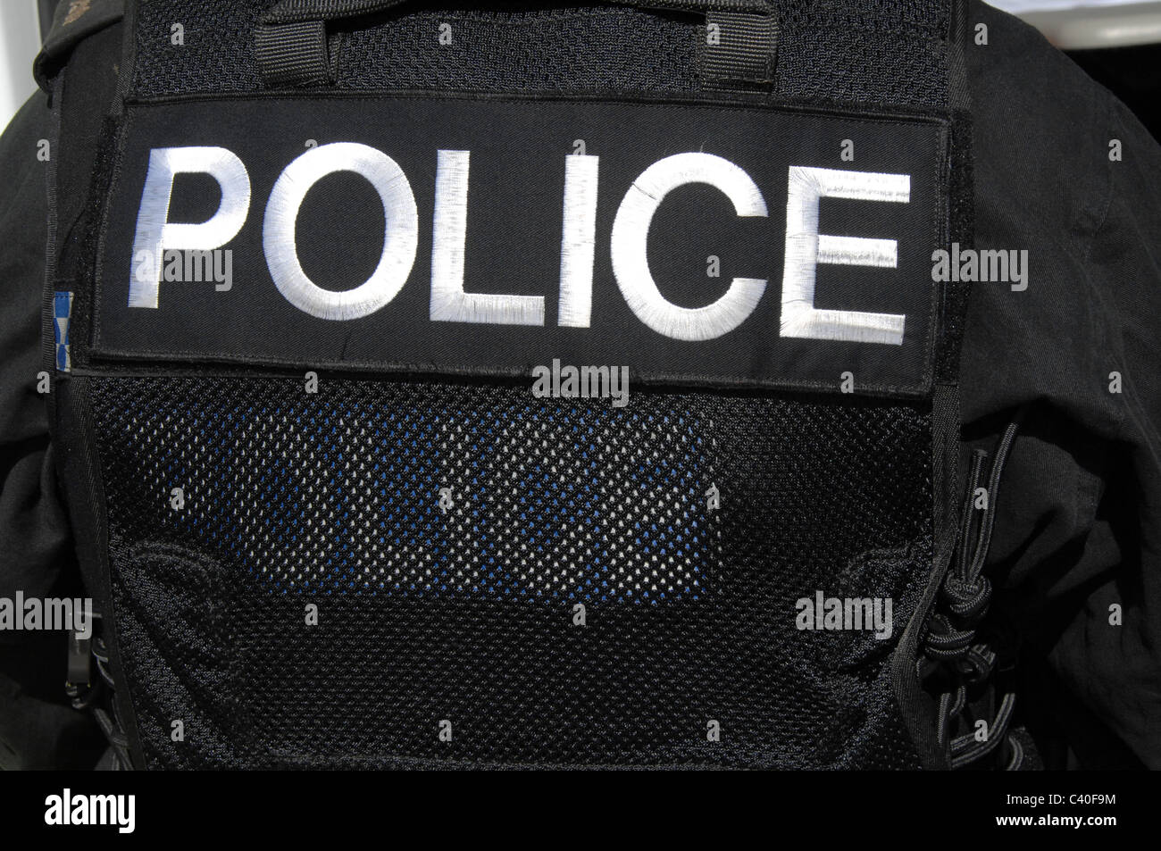 A large POLICE logo on on the rear of a SWAT officer's tactical vest. Stock Photo