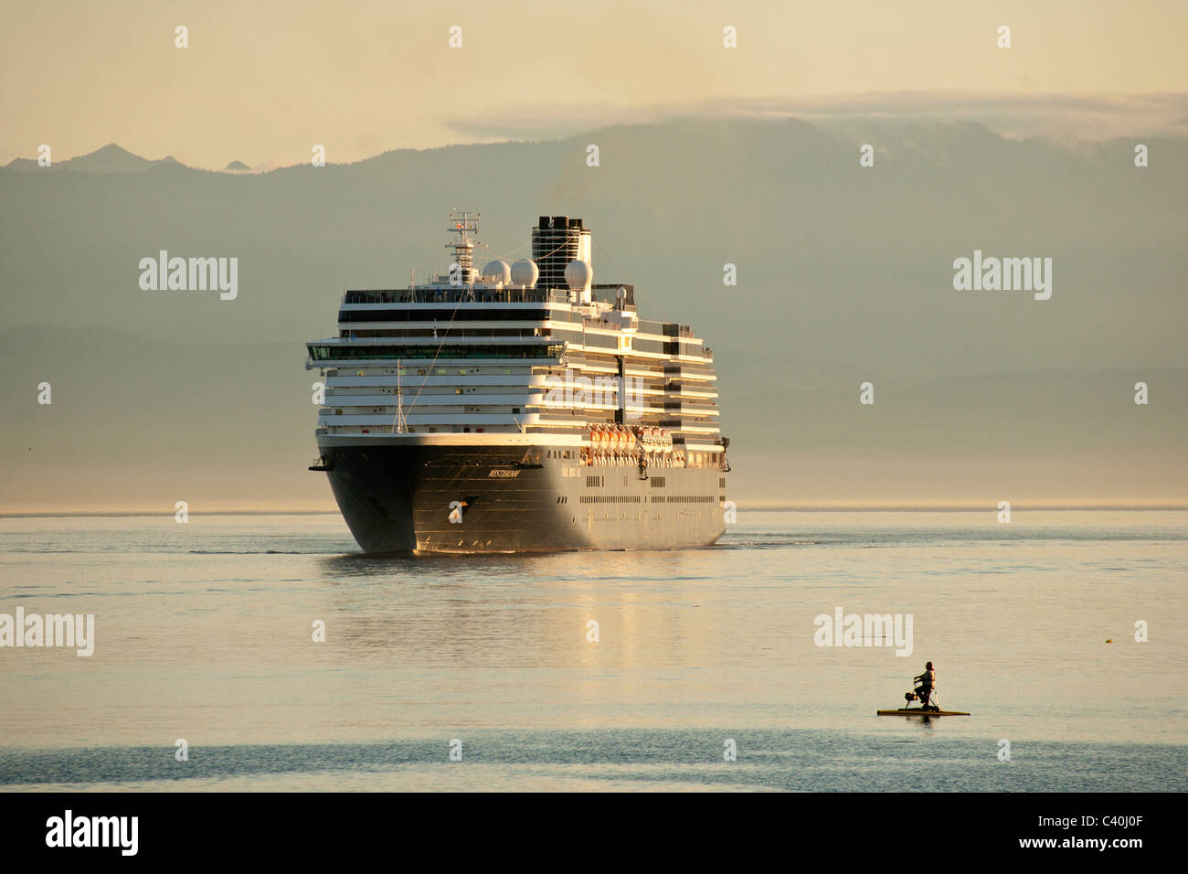 Man on paddleboat with large cruise ship in Juan de Fuca Strait-Victoria, British Columbia, Canada. Stock Photo