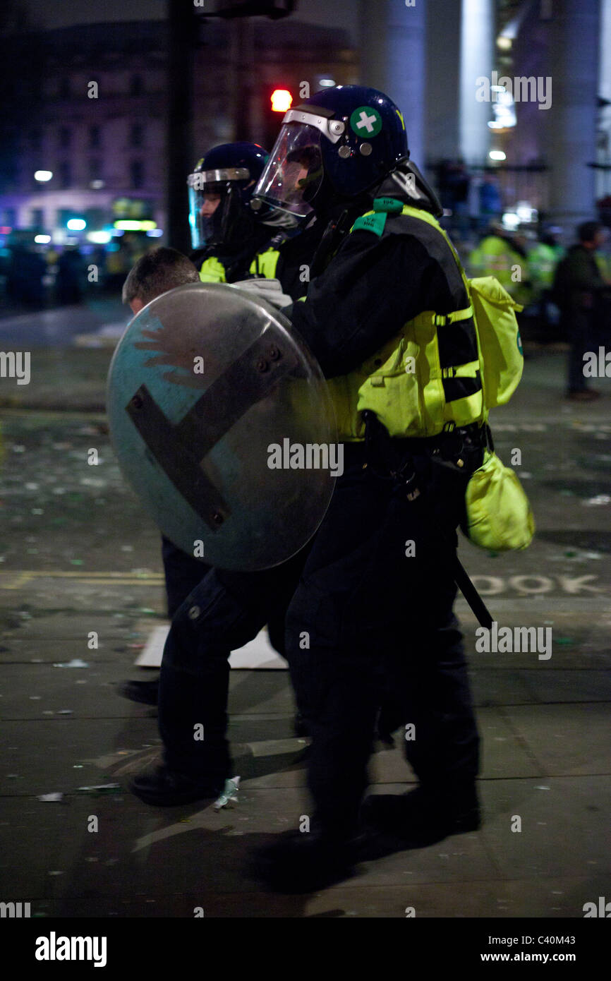 Police in public order gear lead away a protester near Trafalgar Square. Stock Photo