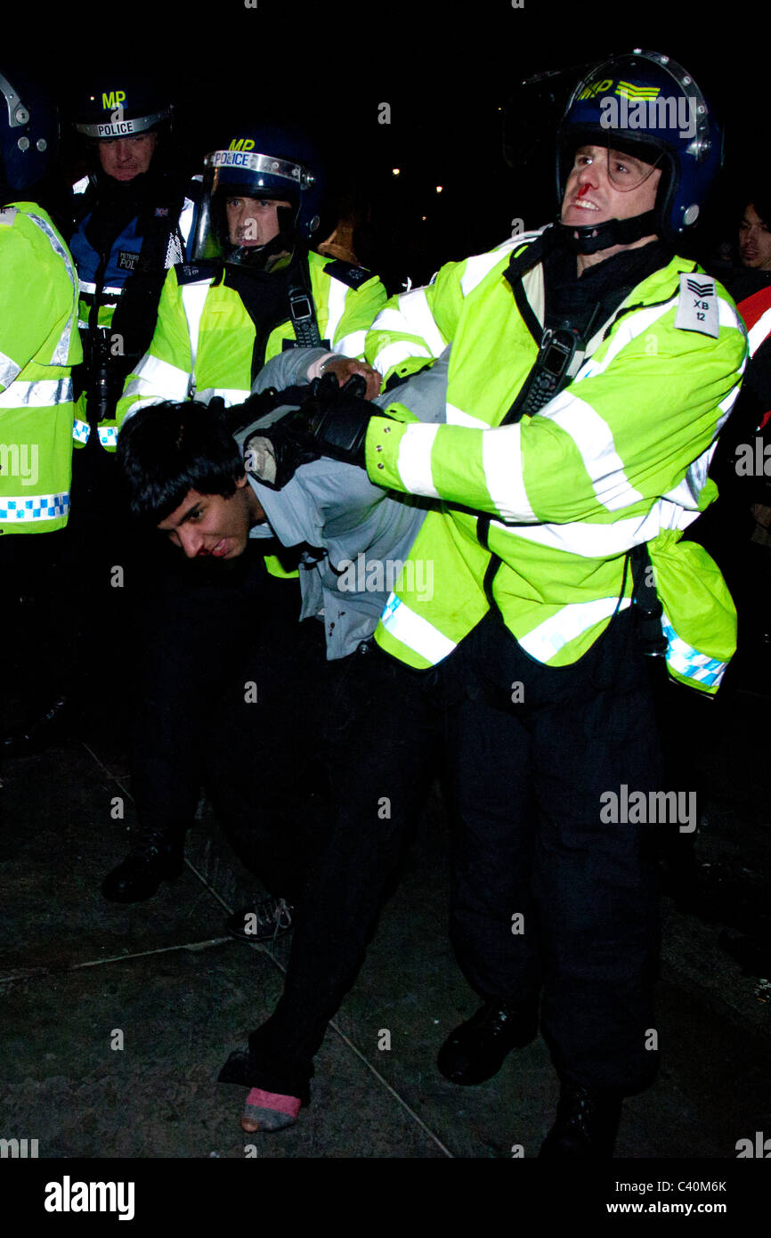 A police officer drags a protester away from the area around Nelson's Column, both with bloody noses. Stock Photo