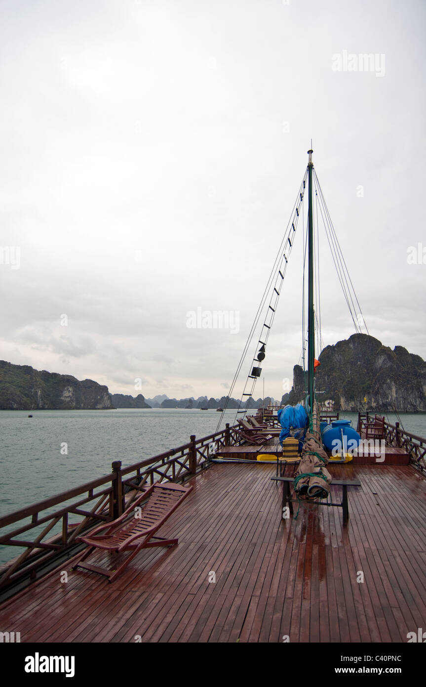 Vertical view of the limestone karsts (rocks) in Halong Bay from the top deck of a traditional wooden junk used for tour guides. Stock Photo